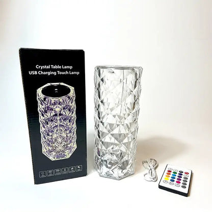 A crystal table lamp with a USB charging cable and a remote control, displayed next to its packaging box.