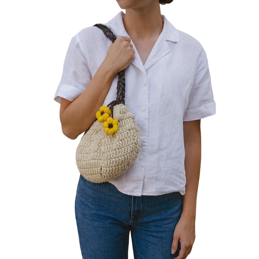 woman holding Beige crochet handbag with a braided handle and yellow flowers